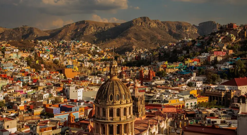 Laptop kijelzőn modern weboldal szerkezet HTML kódblokkban, mellette jegyzetfüzet és kávésbögre